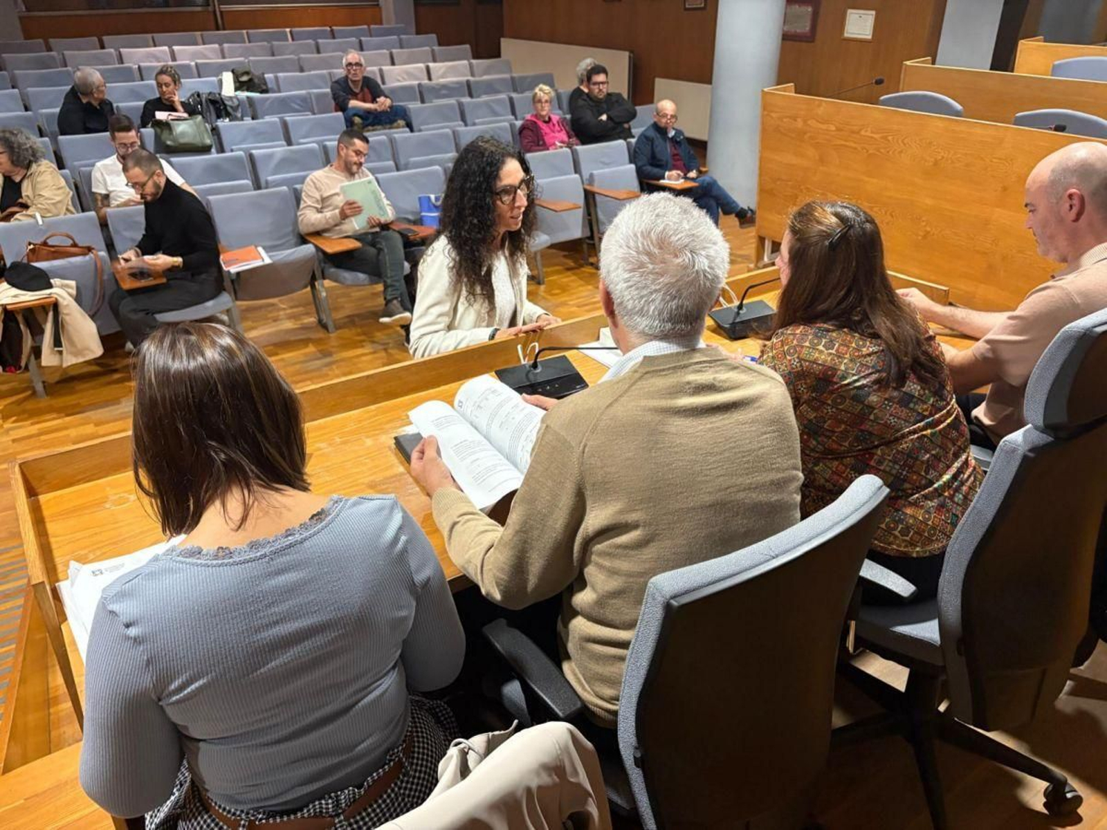 Una hostelera mostrando su propuesta a los alcaldes e interventor.