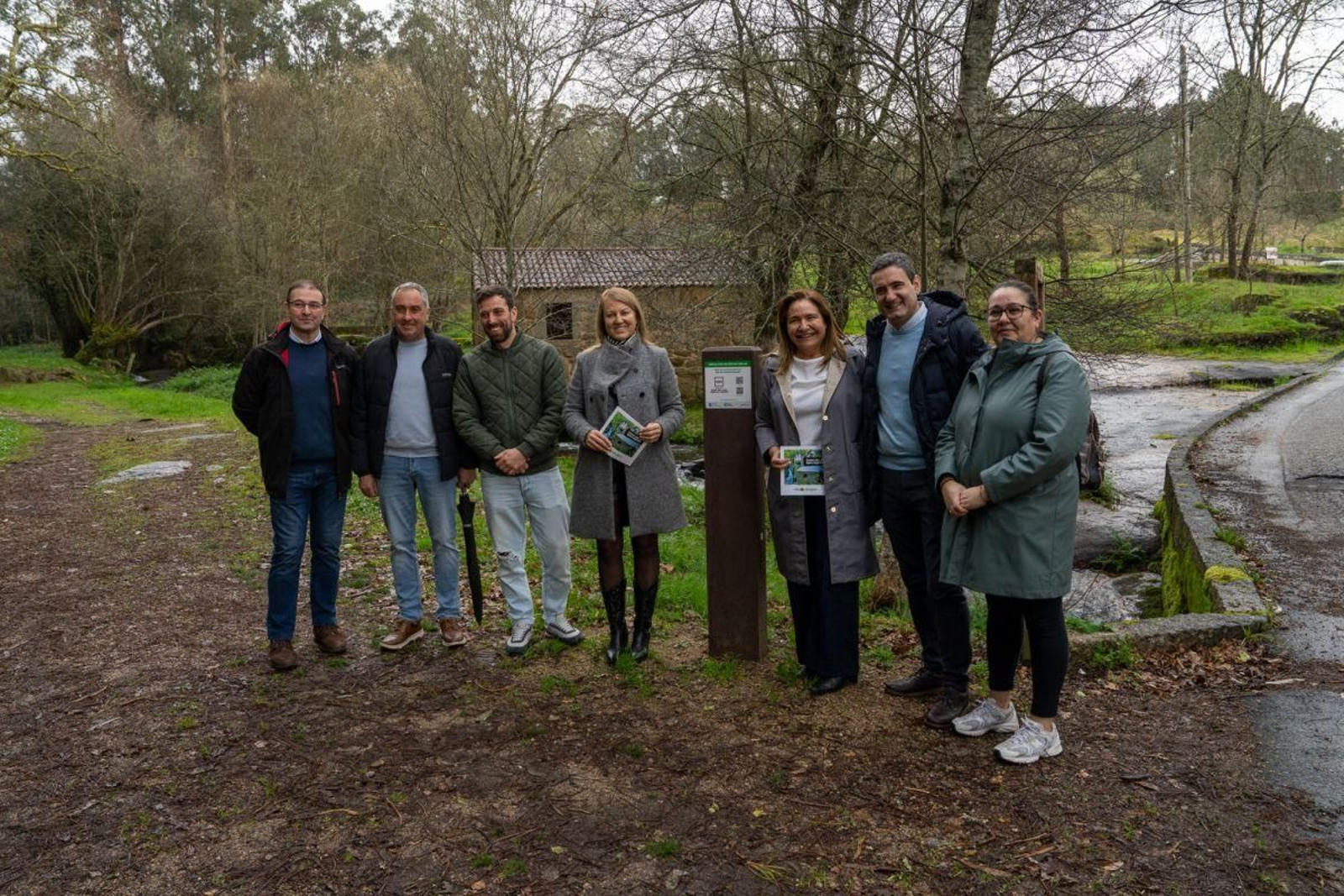 Loli Castiñeira y Ana Ortiz con miembros de la corporación, junto a una de las nuevas señales de micropaisajes.
