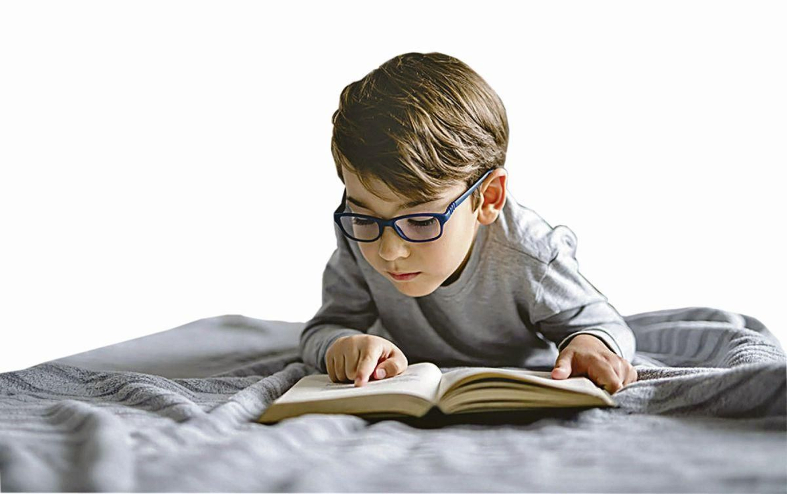 Niño leyendo con atención un libro físico