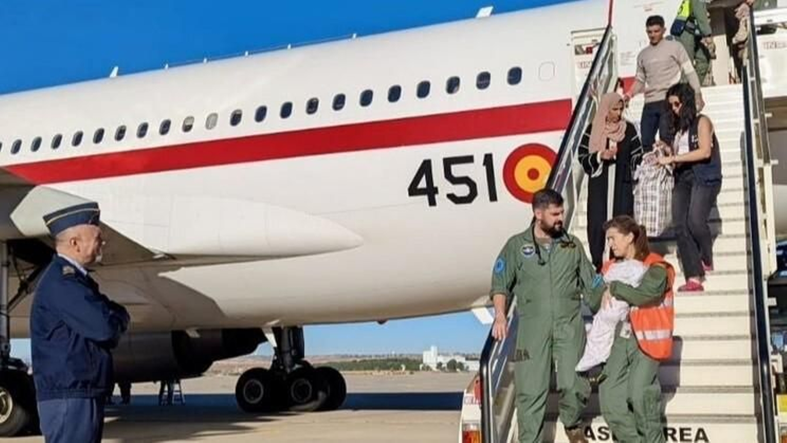 Los equipos médicos saliendo del avión junto a los pacientes y acompañantes evacuados.